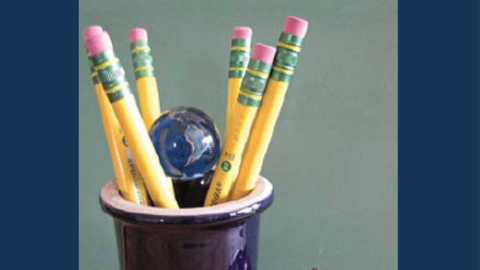 cup of pencils with an apple desk